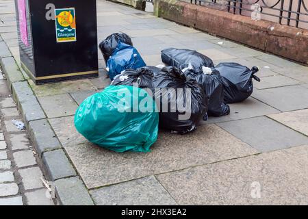 Müllsäcke, die darauf warten, im Freien in einer Straße in Glasgow, Schottland, Großbritannien, gesammelt zu werden Stockfoto