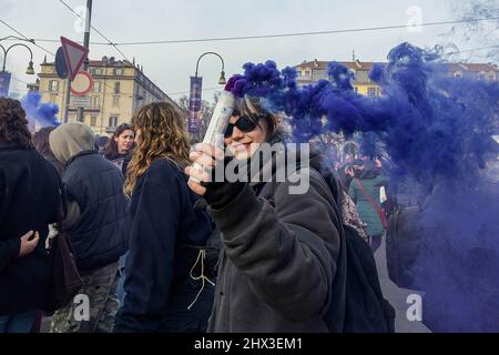 Turin, Italien. 08. März 2022. Eine Frau hält einen purpurnen Rauchflackern, der als Symbol für den globalen feministischen Kampf während des marsches zum Internationalen Frauentag in Turin verwendet wird. Hunderte von Frauen gingen anlässlich des Internationalen Frauentags nach zwei Jahren Haft wegen der Pandemie auf die Straßen von Turin, um dort zu demonstrieren. Kredit: SOPA Images Limited/Alamy Live Nachrichten Stockfoto