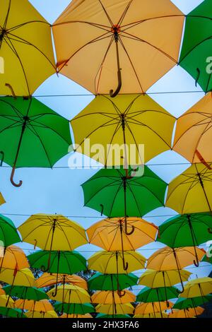 Geöffnete Schirme hängen am Himmel Stockfoto