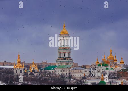 Kiew-Pechersk Lavra. Vögel kreisen über der goldenen Kuppel der Kirche. Stockfoto