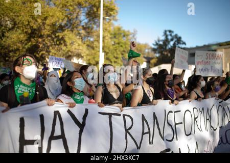 Santiago, Chile. 08. März 2022. Aktivistinnen marschieren mit Plakaten und einem Transparent, das ihre Meinung während des Protestes zum Ausdruck bringt. Feministinnen marschieren am 8.. März in Santiago de Chile zu einer Demonstration, die an die sozialen, politischen und wirtschaftlichen Errungenschaften von Frauen erinnert. (Foto von Vanessa Rubilar/SOPA Images/Sipa USA) Quelle: SIPA USA/Alamy Live News Stockfoto