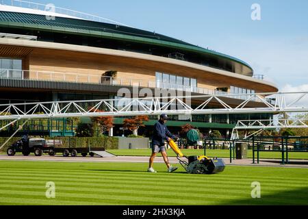 Groundman schneidet das Gras vor dem Platz Nr. 1 des All England Lawn Tennis Club, dem Austragungsort der Wimbledon Championships Stockfoto