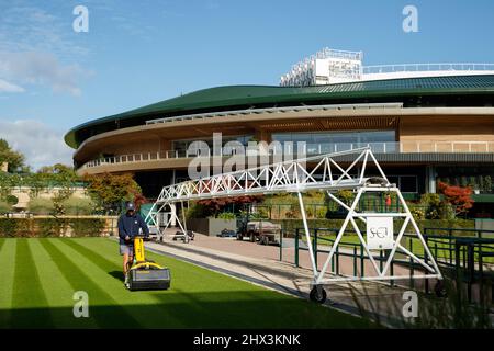 Groundman schneidet das Gras vor dem Platz Nr. 1 des All England Lawn Tennis Club, dem Austragungsort der Wimbledon Championships Stockfoto