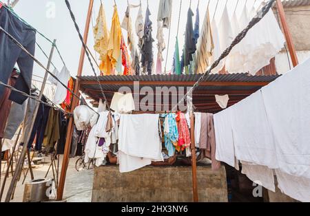 Reinigen Sie frisch gewaschene Kleidung und Handtücher, die zum Trocknen im Freien in Mahalaxmi Dhobi Ghat, einem großen Open-Air-Waschsalon in Mumbai, Indien, hängen Stockfoto