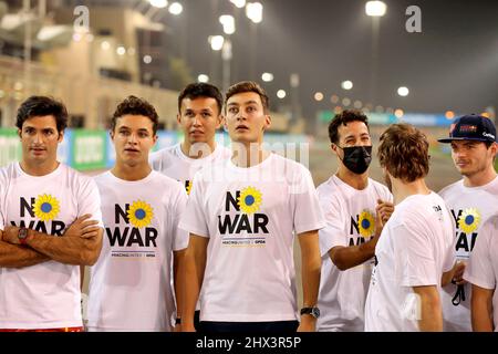 Sakhir, Bahrain. 9.. März 2022. (L bis R): Carlos Sainz Jr (ESP) Ferrari; Lando Norris (GBR) McLaren; Alexander Albon (THA) Williams Racing; George Russell (GBR) Mercedes AMG F1; Daniel Ricciardo (AUS) McLaren; Sebastian Vettel (GER) Aston Martin F1 Team; und Max Verstappen (NLD) Red Bull Racing in T-Shirts zur Unterstützung der GPDA No war #RacingUnited Kampagne. Formula One Testing, Mittwoch, 9.. März 2022. Sakhir, Bahrain. Stockfoto