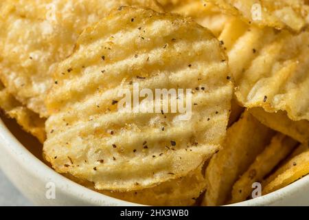 Salz- und Pfefferstreuer Kartoffelchips in einer Schüssel Stockfoto