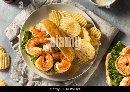 Hausgemachtes Southern Shrimp Po Boy Sandwich mit Kartoffelchips Stockfoto