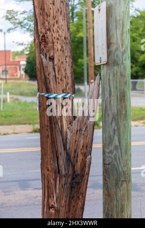 ELKIN, NC, USA-6 JUNE 2021, gebrochener, aber stehender Versorgungsmast, mit Ersatzmast daneben. Stockfoto