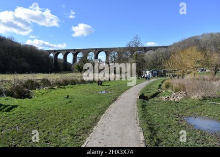 Menschen, die im Porthkerry Country Park vor dem Eisenbahnviadukt spazieren, Barry, Glamorgan, Wales Stockfoto