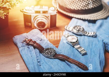 Herren Accessoires auf Holztisch. Nahaufnahme einer Luxus-Herrenuhr mit schwarzem Zifferblatt und Lederarmband. Stockfoto
