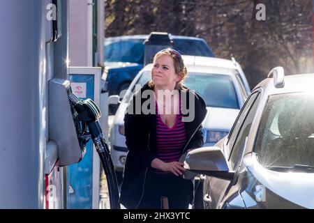 Frau, die ihr Auto mit Kraftstoff betankt Stockfoto