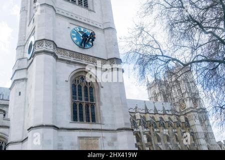 Am 9.. März 2022, in London, England, haben sich die Bauunternehmer abseilen lassen, um das Zifferblatt der St. Margaret's Church in Westminster Abbey zu reinigen. Stockfoto