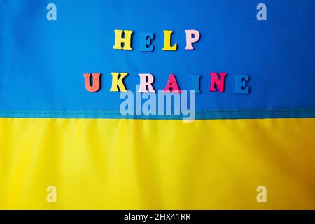 „Hilfe Ukraine“-Slogan. Ukrainische blaue und gelbe Flagge während des Krieges mit Russland. Invasion in der Ukraine. Kampf für Freiheit gegen Aggressor Stockfoto