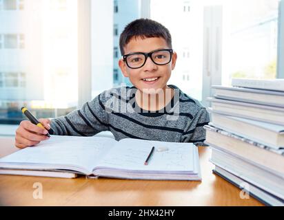 Er weiß bereits, wie wichtig Bildung für seine Zukunft ist. Porträt eines entschlossenen Jungen, der zu Hause seine Hausaufgaben macht. Stockfoto