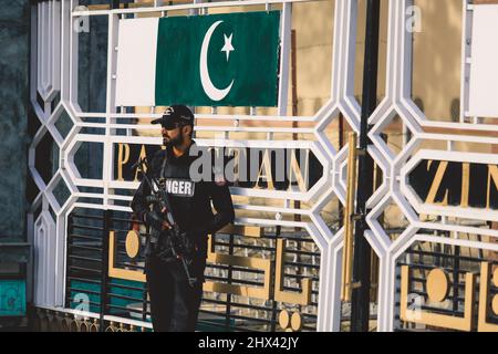 Pakistanischer Soldat in Sonnenbrillen mit der Waffe in der Nähe des Haupttore an der Grenze zu Attari Wagah Stockfoto