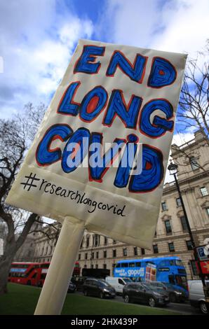 London, Großbritannien. 09. März 2022. Ein Protestler hält während der Demonstration ein Plakat hoch, das Nachforschungen und ein Ende von Long Covid-19 fordert.Eine Protestgruppe auf dem Parliament Square fordert die Regierung auf, etwas Geld in die Erforschung von Long Covid-19 zu investieren. Sie sagen, dass viele Menschen aufgrund gesundheitlicher Komplikationen nach der Exposition gegenüber Covid-19-Varianten in den letzten zwei Jahren lebensverändernde Verletzungen erleiden. Kredit: SOPA Images Limited/Alamy Live Nachrichten Stockfoto