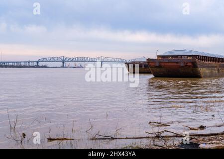 JEFFERSON, LA, USA - 3. MÄRZ 2022: Zwei Lastkähne dockten am Mississippi River mit der Huey P. Long Bridge im Hintergrund an Stockfoto