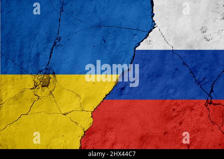 Russland und die Ukraine haben Flaggen an einer Wand mit einem Riss gemalt. Krieg, Konflikt zwischen der Ukraine und Russland Stockfoto