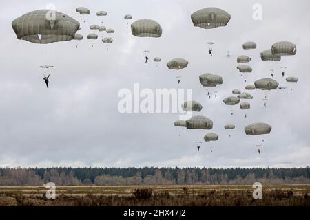 15. Februar 2022 - Joint Base Lewis-McChord, USA - US-Soldaten, die 4. Brigade Combat Team (Airborne), 25. Infantry Division, Fort Richardson, Alaska und Royal Thai Army Soldaten zugeordnet sind, springen aus einem C-17 Globemaster Transportflugzeug mit T-11 Fallschirmen über Rogers Drop Zone, Joint Base Lewis-McChord, Washington, 15. Februar, 2022. Dieses Training ist in Vorbereitung auf eine gemeinsame strategische Airborne Operation (SAO) mit der Royal Thai Army. Die gemeinsame Übung mit der Royal Thai Army verbessert die Fähigkeiten der Fallschirmjäger aus Thailand und den USA, schult die Teilnehmer an T-11-Fallschirmen und Stockfoto