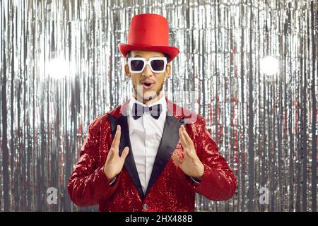 Staunender schwarzer Disco-Mann hält die Messung in den Händen Stockfoto