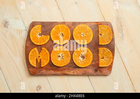 Gute Laune mit orangefarbenen Scheiben, auf einem hölzernen Schneidebrett geschrieben Stockfoto