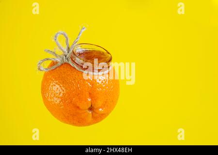 Marmelade Marmelade in einem Glas mit der Form einer Mandarine orange isoliert auf gelb Stockfoto