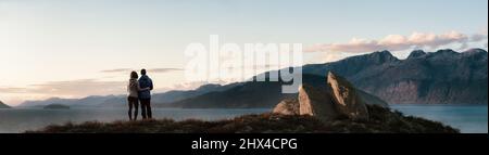 Mann und Frau lieben das Paar, das an der Rocky Ocean Coast steht. Stockfoto