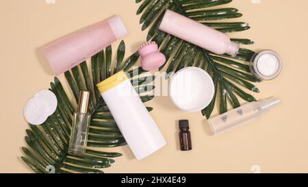 Spa-Hautpflege- und Kosmetikprodukte mit natürlichen Palmblättern auf pastellbeigem Hintergrund. Flach liegend Stockfoto
