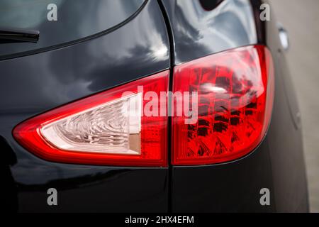 Rückansicht des neuen schwarzen Auto. Closeup Scheinwerfer des Autos. Schwarz Premium city Crossover, Luxus-SUV Heckleuchte Nahaufnahme. Auto Lampe Nahaufnahme. Stockfoto