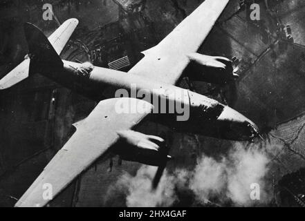 U.S. Marauder Bomber of Over German Airdrome - Ein B-26 Marauder Medium Bomber der U.S. Army Air Force macht seinen Lauf über das bereits schwelende Ziel -- ein deutsches Jagdflugplatz in Tricqueville Frankreich. Dutzende von 200-Pfund-Bomben wurden während des Angriffs auf das Spielfeld auf Hangars, andere Gebäude und Verbreitungsgebiete abgeworfen. 08. März 1944. (Foto: US Office of war Information Picture). Stockfoto