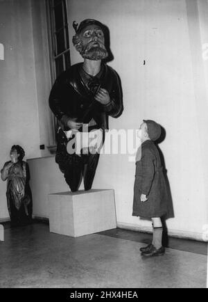 Ausstellung von Schiffskstellern - Ein junger Mann zeigt großes Interesse an einer der alten Galionsfiguren. Am Montag wird im National Maritime Museum in Greenwich eine Ausstellung mit Galionsfiguren aus alten Handelsschiffen eröffnet. 30. Oktober 1953. (Foto von Daily Mail Contract Picture). Stockfoto