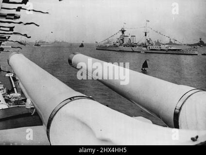 Fleet at Spithead für die große Krönung - Bewertung durch den König - Eine Geldstrafe der H.M.S. Hood und andere Schiffe der Flotte von der H.M.S. aus gesehen Repulse über die riesigen Waffen des letzteren, bei Spithead bereit für die Überprüfung. Die Flotte wird nun in Spithead zusammengebaut, wo am kommenden Donnerstag die große Naval Review von König George VI stattfinden wird. Schiffe der Marines der Welt sind vertreten und der spektakuläre Anblick am kommenden Donnerstag wird von vielen Tausenden beobachtet werden. 17.Mai 1937. (Foto von Keystone). Stockfoto