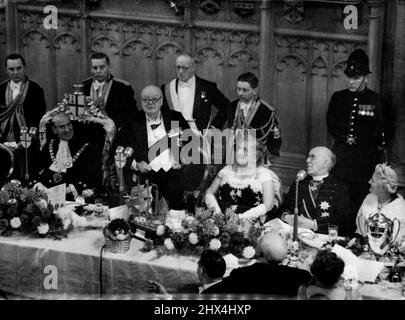 Sir Winston spricht beim Bankett des Oberbürgermeisters - Premierminister Sir Winston Churchill blickt in jovialer Stimmung über die Spitze seines Spektakels und spricht beim Bankett des Oberbürgermeisters, das heute Abend (Dienstag) im neu restaurierten Guildhall stattfand. Sir Winston zuhören: Ganz links der neue Oberbürgermeister von London, Alderman Seymour Howard; rechts vom Premierminister (von links nach rechts) die Bürgermeisterin, Frau Howard; Dr. Geoffrey Fisher, Erzbischof von Canterbury; Und Lady Churchill. 09. November 1954. (Foto von Reuterphoto). Stockfoto