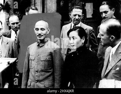Der 'starke Mann' der Kette erhält die Pressefrau als Interpretin -- General und MME. Chiang Kai-Shek fotografierte mit Journalisten nach dem Interview in Nanking. FRAU Kai-Shek wird hier als hübsche Frau gesehen, auf ihrem hohen Kragen sie ***** . FRAU Chiang Kai-Shek, die in China ebenso viel Macht besitzt wie ihr berühmter Ehemann, General Chiang Kai-Shek, fungiert als Dolmetscher, wenn die Presse interviewt wird. All diese Interviews werden auf geheimen Plades abgehalten, wie auch andere wichtige Treffen, ***** Ihrer wichtigen Position für ***** . 10. November 1937. (Foto von Keystone) Stockfoto