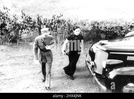 Chiang Kai-Sheks Abfahrt aus Hankow -- Chinesischer Kommandant verlegt sein Hauptquartier -- General Chiang Kai-Shek und seine Frau, die aus einem Auto zurückkehrt - fahren kurz vor ihrem Abflug aus Hankow. General Chiang Kai-Shek, Kommandant der chinesischen Streitkräfte, hat sich an einem geheimen Treffpunkt mit Sir Archibald Clark Kerr, dem britischen Botschafter in China, zusammengetan. Gen Chiang Kai-Shek und seine Frau blieben bis zur Besetzung durch die Japaner in Hankow und verließen dann das Land, um ein neues Kampfquartier in Zentralchina zu errichten. 11. August 1938. (Foto von Associated Press Photo). Stockfoto