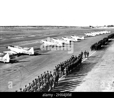 Mehr Canadian Airmen -- die Flieger der Royal Canadian Air Force im Camp Borden schwingen sich geschickt an einer Reihe von Yale-Trainingsflugzeugen vorbei, nachdem sie der ersten Gruppe von nicht-beauftragten Piloten im Training Flügel präsentiert haben. 10.Mai 1940. (Foto von ACME). Stockfoto