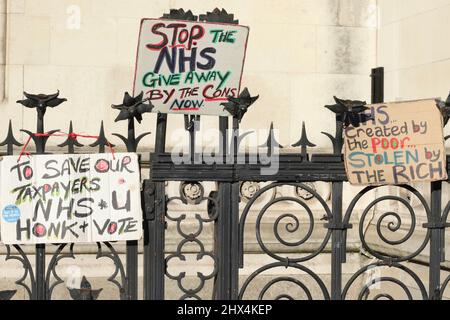 Weibliche Protestierenden stehen mit Schildern - Rette den NHS vor den Royal Courts of Justice, London, Großbritannien Stockfoto