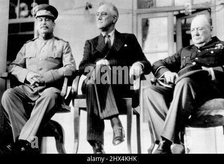 Prinzipale auf der Teheran-Konferenz -- Joseph Stalin, der russische Premierminister (links), sitzt mit dem US-amerikanischen Präsidenten Franklin D. Roosevelt und Premierminister Winston Churchill (rechts) auf der Veranda der russischen Botschaft in Teheran, Iran, Während ihrer viertägigen Konferenz, auf der sie Pläne auszeichneten, die gesamte militärische Macht Russlands, der Vereinigten Staaten und Großbritanniens auf eine „unerbittlich wachsende“ Basis zu konzentrieren, um den Sieg über Deutschland zu garantieren. Dies ist eines von einer Serie von Fotos auf der Konferenz, die von US Army 12. Air Forces Fotografen gemacht wurden und vom Kriegsministerium in Washington erfreut waren. Decemb Stockfoto