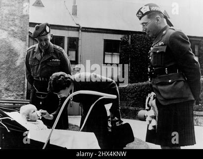 „Nun, Ein guter harter Schlag für Mama!“ -- Ein sehr informelles Bild von Prinzessin Elizabeth, die ihre Tochter Prinzessin Anne die Nase wischt, bevor sie LT. Col. J. A. Farmer (rechts) Officer trifft, der die Argyll und Sutherland Highlanders von Kanada befehligt und LT. Col. Neilson, der die 1. Argyllen in Korea befehligte. Die Pfeifenband der kanadischen Argyll- und Sutherland-Highlanders spielte vor der Familie der Prinzessinnen Elizabeth und Margaret und Prinzessin Elizabeth im Birkhall on the Deeside. 25. August 1951. (Foto von Fox Photos). Stockfoto