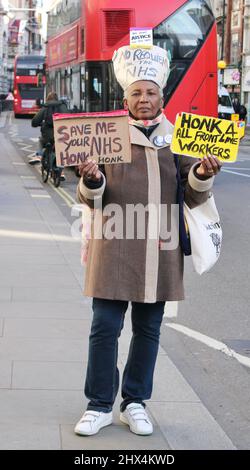 Weibliche Protestierenden stehen mit Schildern - Rette den NHS vor den Royal Courts of Justice, London, Großbritannien Stockfoto