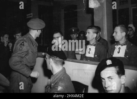 Kramers verteidigungsrat, Major T.C.M. Winwood, der las, der vor seinem Eintritt in die Armee ein Londoner Klischee war, spricht während des ersten Gerichtsverfahrens in Luneberg mit dem Biest von Belsen. Die ersten Kriegsverbrecherprozesse in Deutschland begannen am 17. September in Lüneburg, als Josef Kramer, „das Tier von Belsen“, im eigens dafür eingerichteten Gerichtssaal in Lünenburg Stellung nahm, Zusammen mit 29 Männern und 19 Frauen, die ebenfalls wegen Misshandlung alliierter Kriegsgefangener angeklagt werden. 15. Oktober 1945. (Foto von Associated Press Photo) Stockfoto