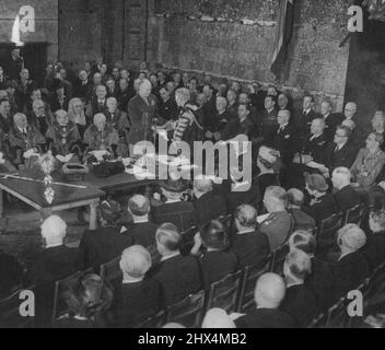 General Eisenhower erhält die Freiheit der Stadt London -- die Szene in der historischen Guildhall, in der General Eisenhower das Token Sword of Honor - das gebogene Schwert, das der berühmte Herzog von Wellington bei der Schlacht von Waterloo getragen hat - vom Oberbürgermeister erhält. Hinter dem Premierminister und dem amerikanischen Botschafter sitzt im Vordergrund der jetzige Herzog von Wellington in Militäruniform, der das Schwert für diesen Anlass präsentierte. Am Begrüßungstisch sind viele angesehene Personen zu erkennen.General Dwight D. Eisenhower fuhr durch jubelnde Menschenmengen in die Guildhall, wo er mit dem Auto in die Stadt fuhr Stockfoto