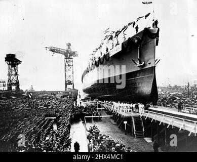 Deutschland startet einen weiteren Cruiser -- auf der Luftbildgrafik aus Berlin zeigt das Schiff, das den Schlupfschein verlässt, den Nazi-Gruß, der von den Stahlhelmen auf der linken Seite gegeben wird. Eine gewaltige Menge von Zivilisten, Steel Hilmets und Hiterlites, war gestern Zeuge des Starts des zweiten Panzerkreuters „Admiral Scheer“ in Wilhelmshaven. Die Tochter des verstorbenen Admiral Scheers ***** Das Schiff. 2. April 1933. Stockfoto