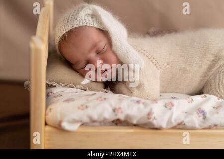 Ein neugeborenes Baby schläft in einer Krippe, das Konzept der Mutterschaft, Familie, Pflege, Zärtlichkeit. Hintergrundbild. Stockfoto