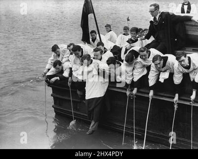 Der Choirboy setzt seinen Fuß in IT und schlägt die Thames Boundary -- der Choirboy wird über die Seite des Bootes gesenkt, um auf der Themse zu "treten", während andere Choirboys die Grenze mit Stöcken schlagen.Da sich die Parish-Grenze in die Themse erstreckt, stellten die Choirboys vom St. Dunstan's College, Catford (London), Raus in einem Boot, um die traditionelle Zeremonie, bei der die Grenzen der bombardierten Stadtkirche von St. Dunstan im Osten Londons überschritten werden, gründlich zu machen. Ein Choirboy wurde über die Seite gesenkt, bis sein Fuß das Wasser berührte. Andere Chorknaben berührten das Wasser mit Stöcken. 04.Mai 1949. (Foto von Reuterp Stockfoto