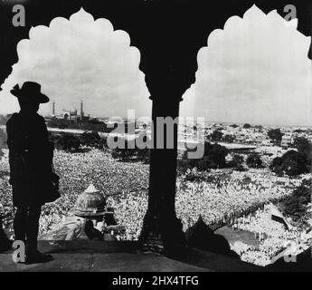 Jahrestag der Unabhängigkeit Indiens beobachten - ein bewaffneter Gurkha wird am 15. August in Neu-Delhi gegen den indischen Himmel geschildet, während Tausende von Indern den Hof unter dem Roten Fort von Delhi drängen, um eine Rede ihres Premierministers Pandit Jawarhalal Nehru zu hören, die den ersten Jahrestag der Unabhängigkeit ihres Landes anläßlich des ersten Jahrestages der Unabhängigkeit begeht. Die Zeremonie beinhaltete das Heben der Dominion Flagge (unten rechts). 20. August 1948. (Foto von AP Wirephoto). Stockfoto