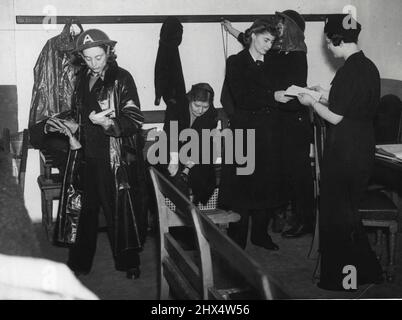 A.R.P. In der Old Bailey - Station Officer Frau Rita Cohen (rechts) Handhabung Anweisungen an eine Krankenwagen-Crew, kurz vor dem Dienst zu gehen. Unten, wo sich das Gericht im Old Bailey befindet, wurde ein A.R.P. Depot eingerichtet. Krankenschwestern in blauen Overalls und weißen Kappen sind zu sehen, wie sie entlang der Korridore eilen. Sie sind Teil der Kriegsbevölkerung, die in das Gebäude eingezogen ist. 02. Dezember 1940. (Foto von London News Agency Photos Ltd.) Stockfoto