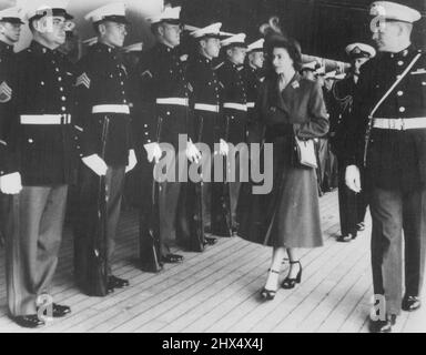 Königlicher Besuch bei U.S. Cruiser -- Prinzessin Elizabeth inspiziert eine Ehrenwache der Vereinigten Staaten, als sie den US-amerikanischen Kreuzer 'des Moines' besuchte, der hier vor Anker lag. Der Herzog von Edinburgh, der die Prinzessin bei ihrem ersten gemeinsamen Engagement hier begleitet hat, ist hinten zu sehen. 10. Dezember 1949. Stockfoto