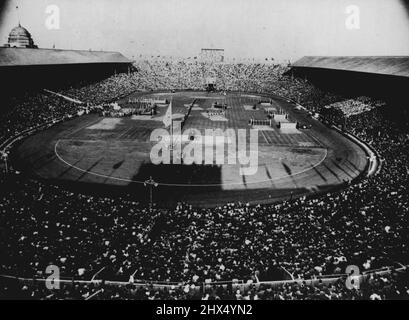 Abschluss der Spiele der XIV. Olympiade: Ein Blick ins Wembley-Stadion, 14. August, zeigt die Menge bei der Übergabe der olympischen Flagge an den Bürgermeister von London, der die Flagge bis zur XV. Olympiade in Helsinki behalten wird. Auf diesem Bild fliegt die olympische Flagge in der Mitte, die Flamme im Hintergrund, während auf der Tribüne der Ehre am linken Stand J. Sigfrid Edstrom, Präsident des Internationalen Olympischen Komitees, und Sir Frederick Wells, Oberbürgermeister von London, zu sehen ist. 14. August 1948. (Foto von Rota Picture) Stockfoto