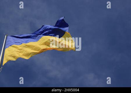 Die Flagge der Ukraine flattert am blauen Himmel. Große gelb blaue ukrainische Nationalstaatsflagge, Stadt Kiew Ukraine Stockfoto